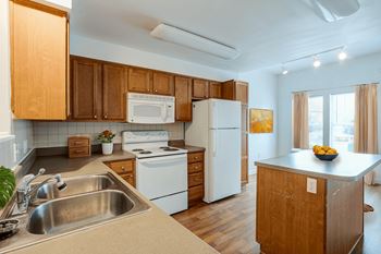A kitchen with wooden cabinets and white appliances.